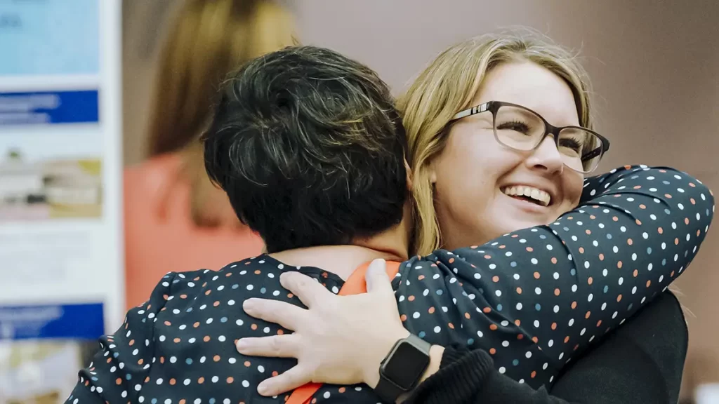 two people in peer recovery hugging